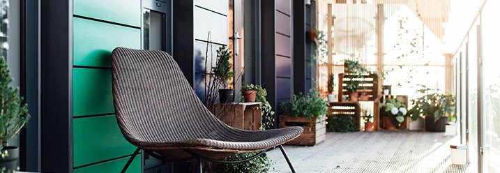 Sonniger Balkon mit Sessel und Pflanzen